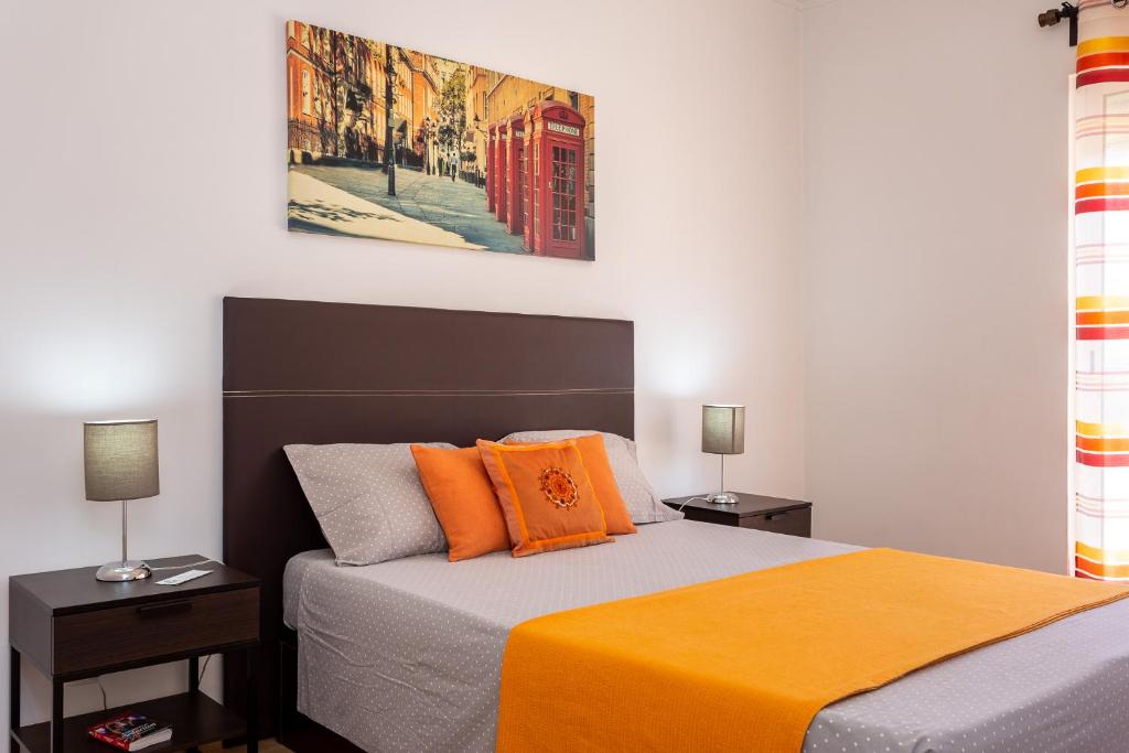 a bedroom with a bed with an orange blanket at Graca House in Lisbon