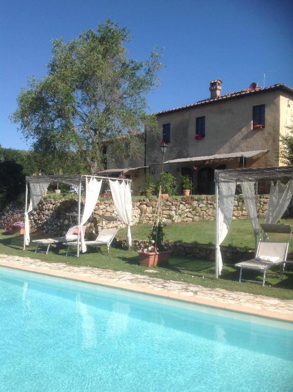 - une vue extérieure sur une maison et une piscine dans l'établissement La Canonica Di San Michele, à Monteriggioni