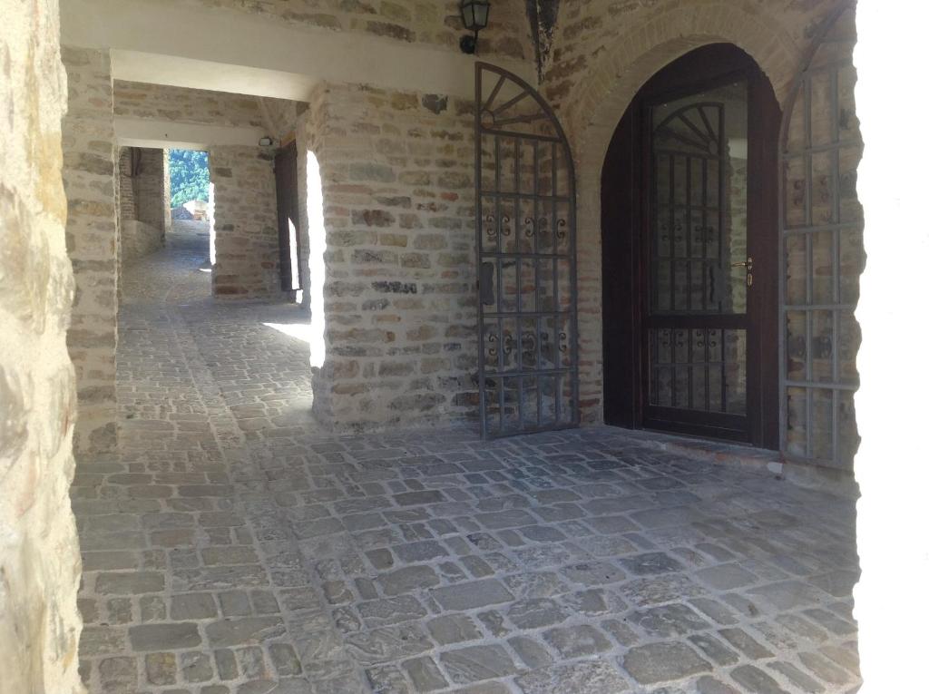 un pasillo vacío de un edificio de piedra con una puerta en Le Copertelle Bed & Breakfast, en Serra San Quirico