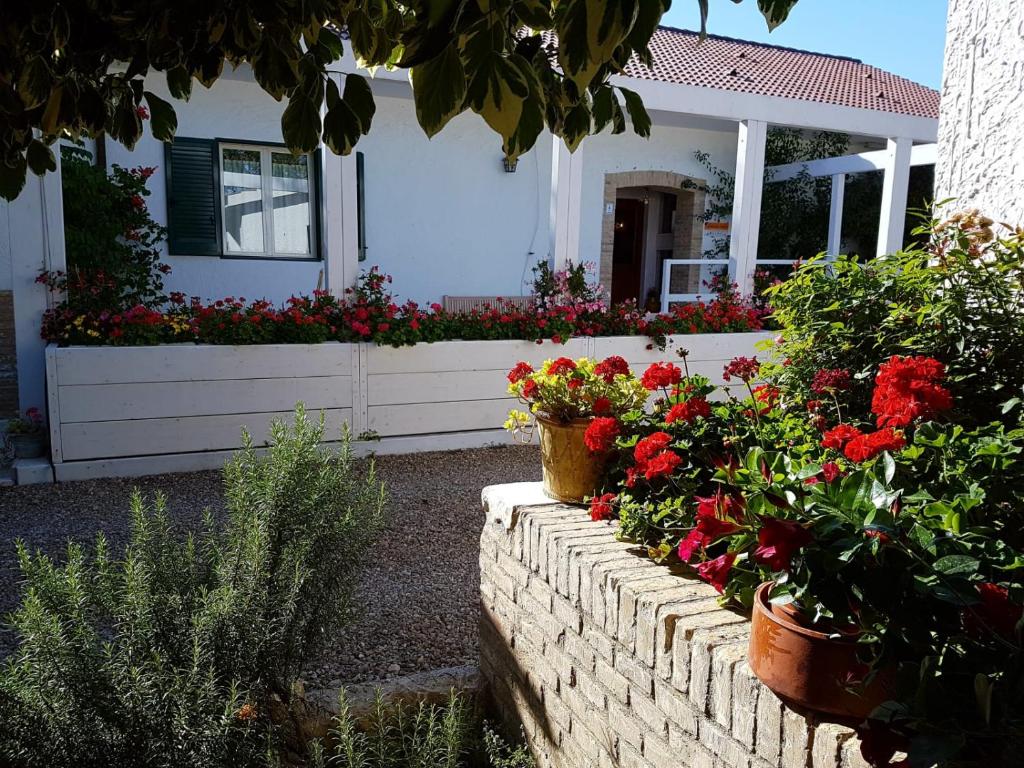 un mur en briques avec des fleurs devant une maison dans l'établissement Agriturismo Masseria Mascitelli, à Orta Nova