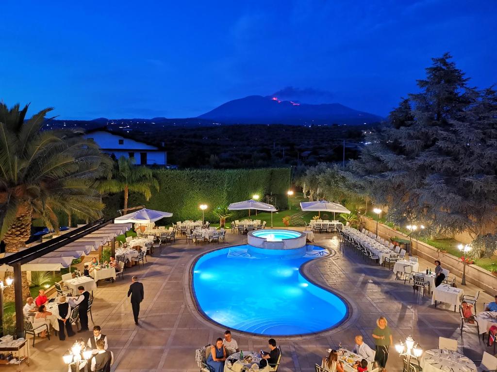 a view of a pool at a resort at night at Hotel Ristorante Paradise in Santa Maria di Licodia