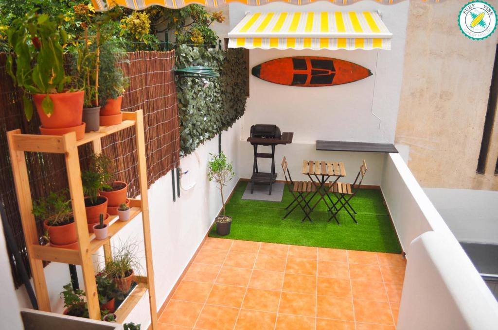 a balcony with a table and chairs and plants at Surf Vibe Guest House in Faro