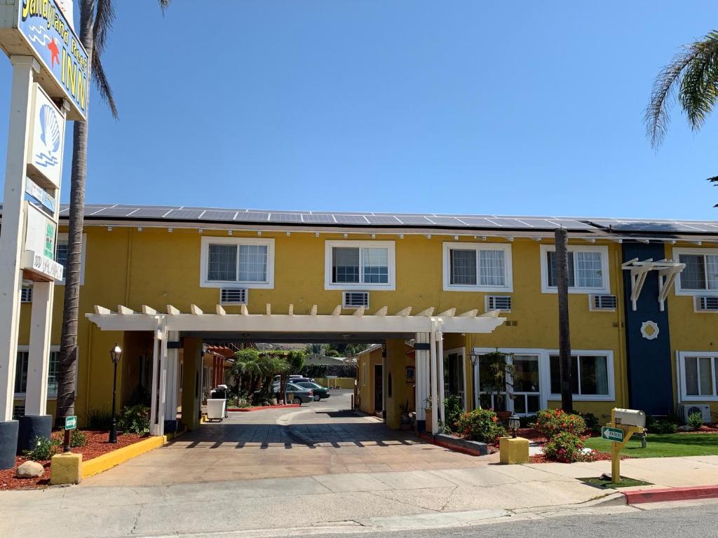 um edifício amarelo com um arco em frente em Sandyland Reef Inn em Carpinteria