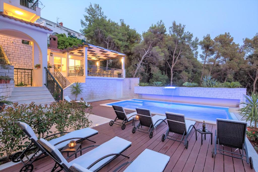 a patio with chairs and a swimming pool at Villa Fani - Apartments in Trogir in Trogir