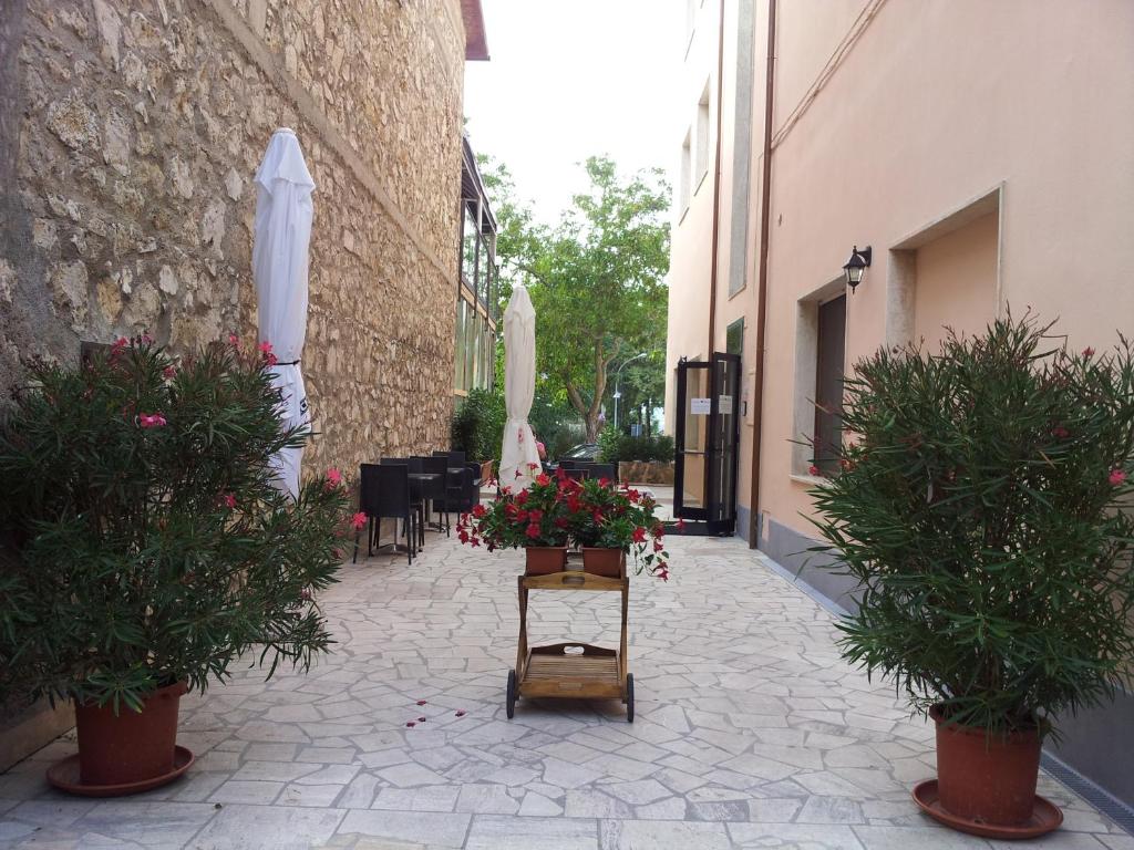 a courtyard with a table with flowers and an umbrella at Tellus Saturnia in Saturnia