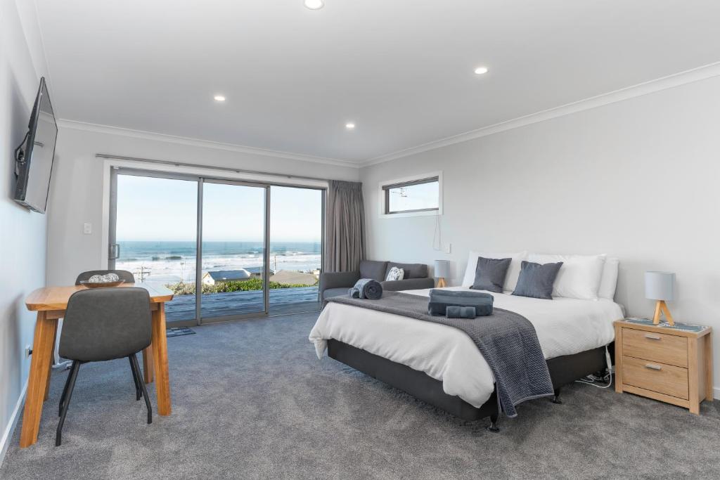 卡卡角的住宿－Kaka Point Views Apartment 2，一间卧室配有一张床、一张书桌和一个窗户。