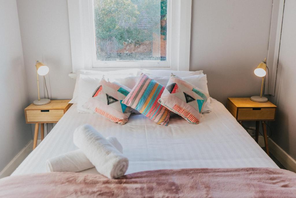 a bedroom with a white bed with pillows and a window at Duke of Wellington Hotel in New Lambton