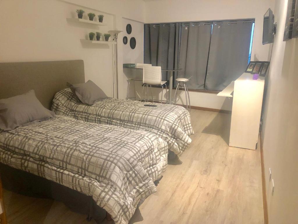 1 dormitorio con 2 camas, mesa y ventana en Departamento Centro Vista al Obelisco para 5 personas en Buenos Aires