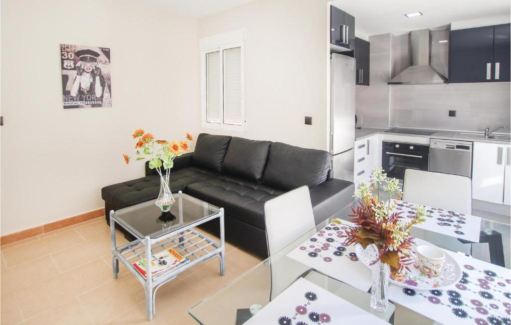 a living room with a black couch and a kitchen at Awesome Apartment In Alicante With Wifi in Alicante