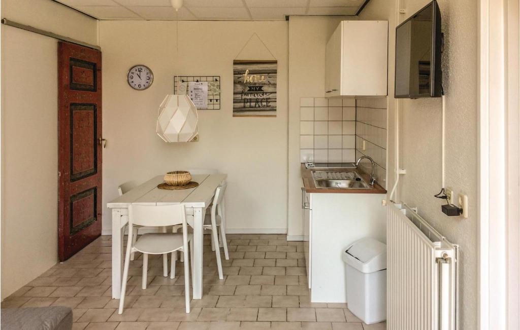 eine kleine Küche mit einem weißen Tisch und Stühlen in der Unterkunft Appartement 3 - De Eekhof in Hindeloopen