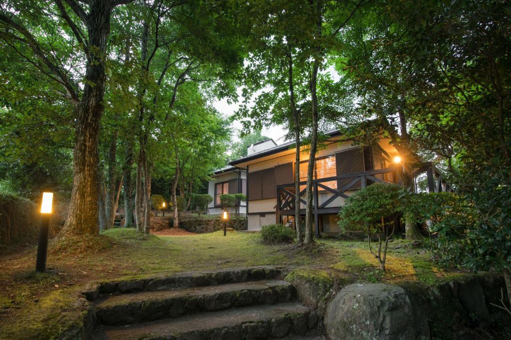 a house in the middle of a forest at night at 'Imi Ola House in Yufuin