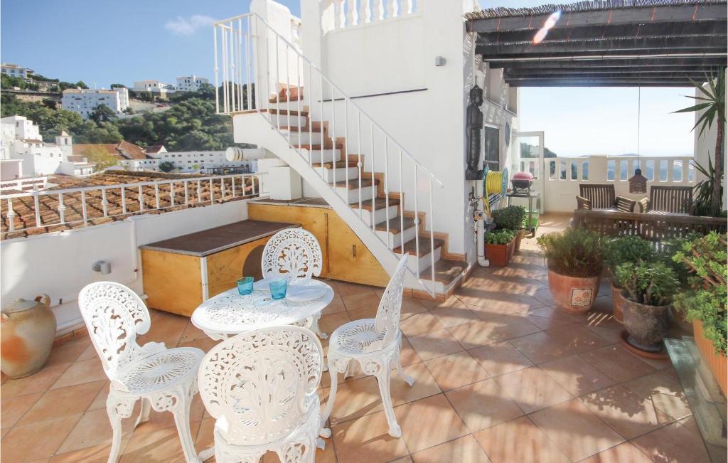 un patio con sillas blancas, una mesa y escaleras en Beautiful Home In Casares With 2 Bedrooms And Wifi, en Casares