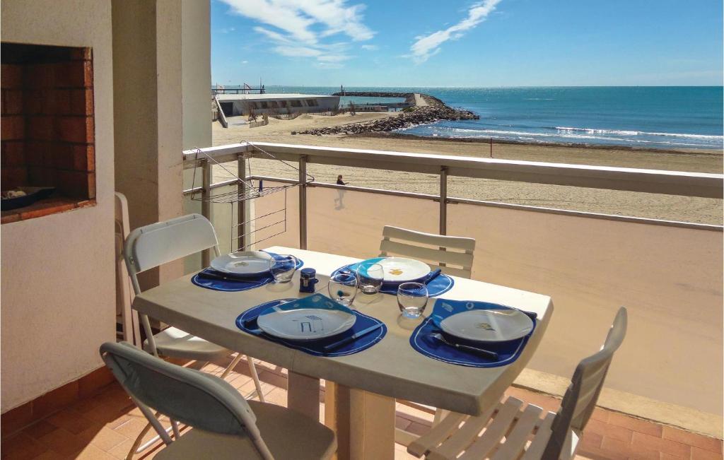 a table with chairs and a view of the beach at Stunning Apartment In Carnon Plage With 2 Bedrooms in Carnon-Plage