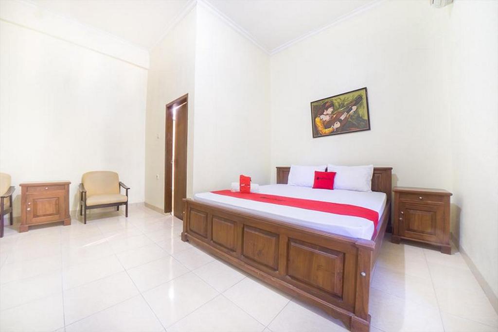 1 dormitorio con 1 cama y 1 silla en RedDoorz near Nusa Cendana University en Kupang