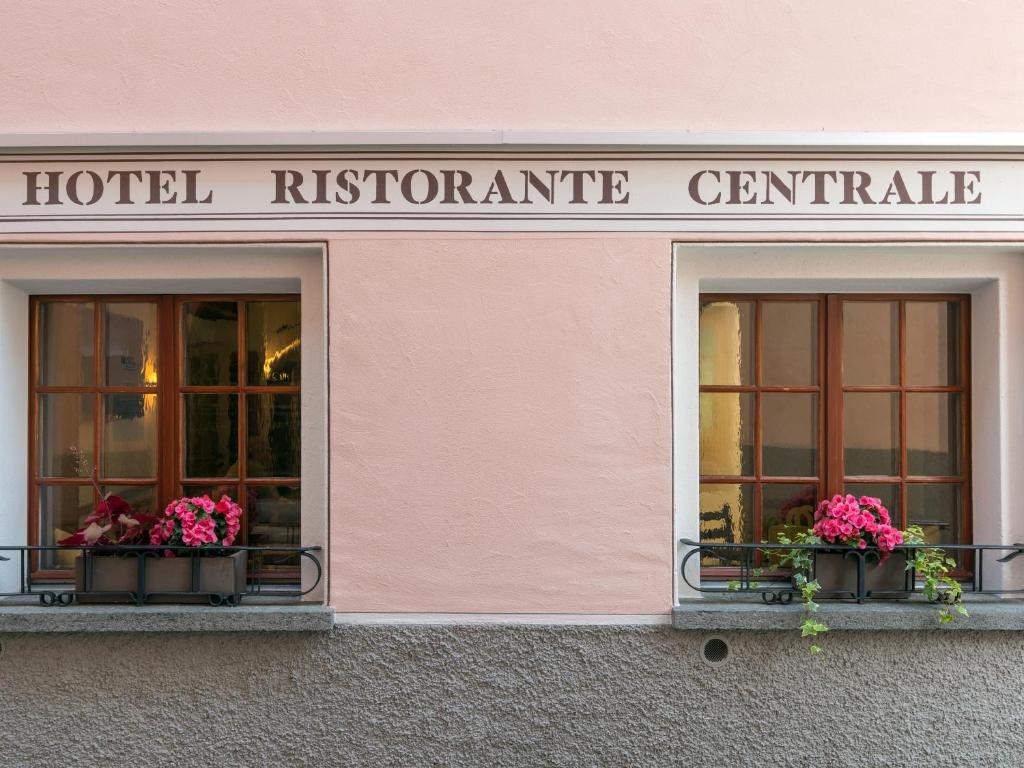 zwei Fenster eines Hotels mit Blumen drauf in der Unterkunft Hotel Centrale, Typically Swiss in Poschiavo