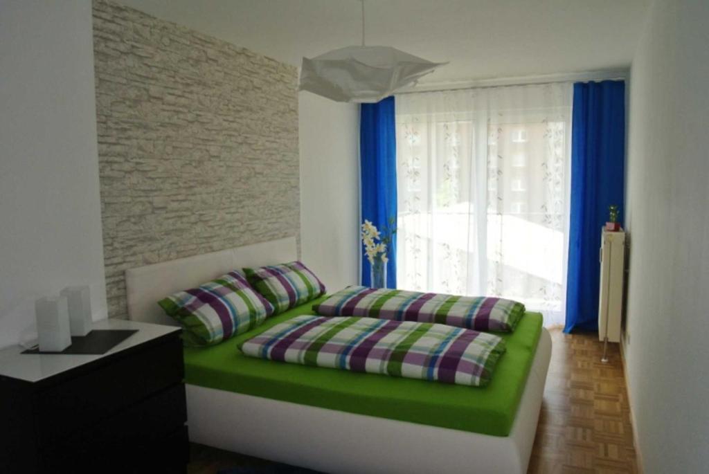 フライブルク・イム・ブライスガウにあるFerienwohnung Betzenhausen Spatzのベッドルーム(緑のソファ、窓付)
