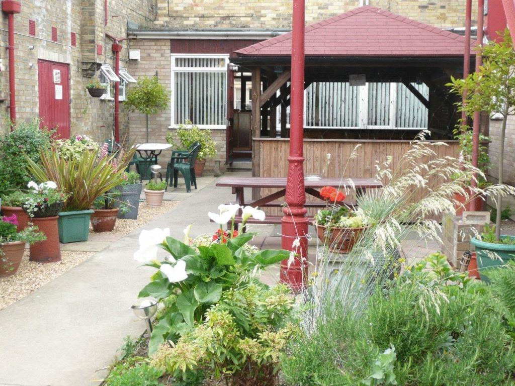 a garden with a table and a gazebo at Newark Hotel Peterborough in Peterborough