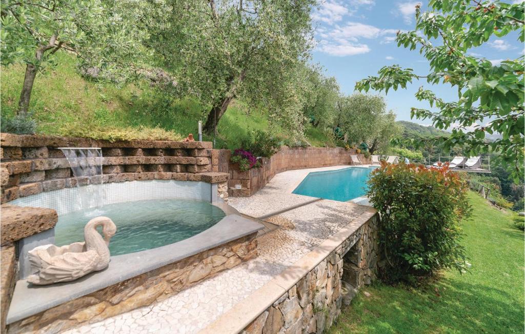 una piscina con un cisne en una pared de piedra en Casa Di Giulio, en Massaciuccoli