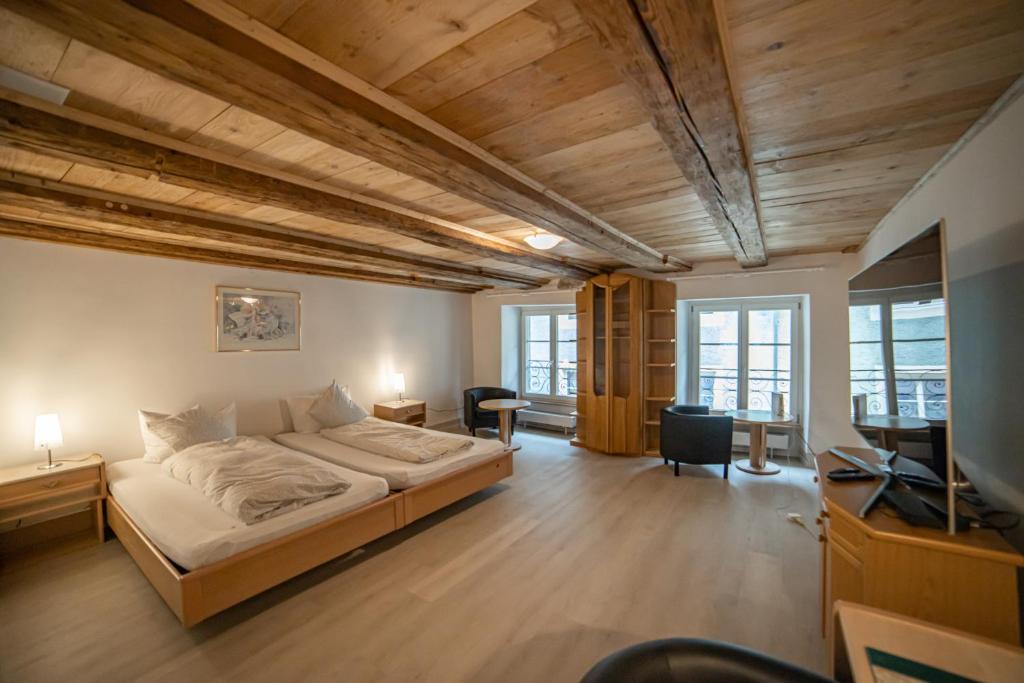 a bedroom with a bed and a desk and a tv at Hotel Mokka Laufenburg in Laufenburg