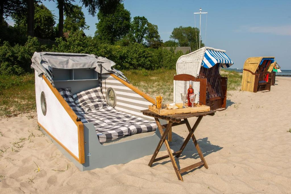 a bed and a table on the beach at Schlafstrandkorb Nr.2 in Sierksdorf