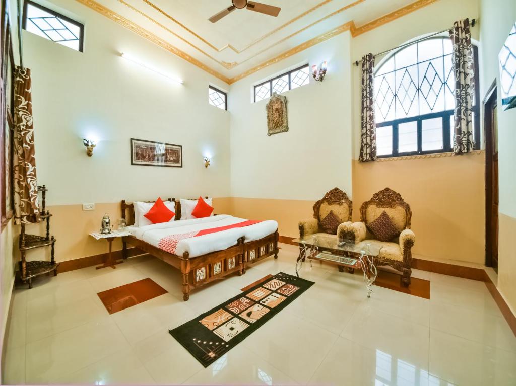 a bedroom with a bed and two chairs in it at Jhankar Mansion A Heritage Haveli in Būndi