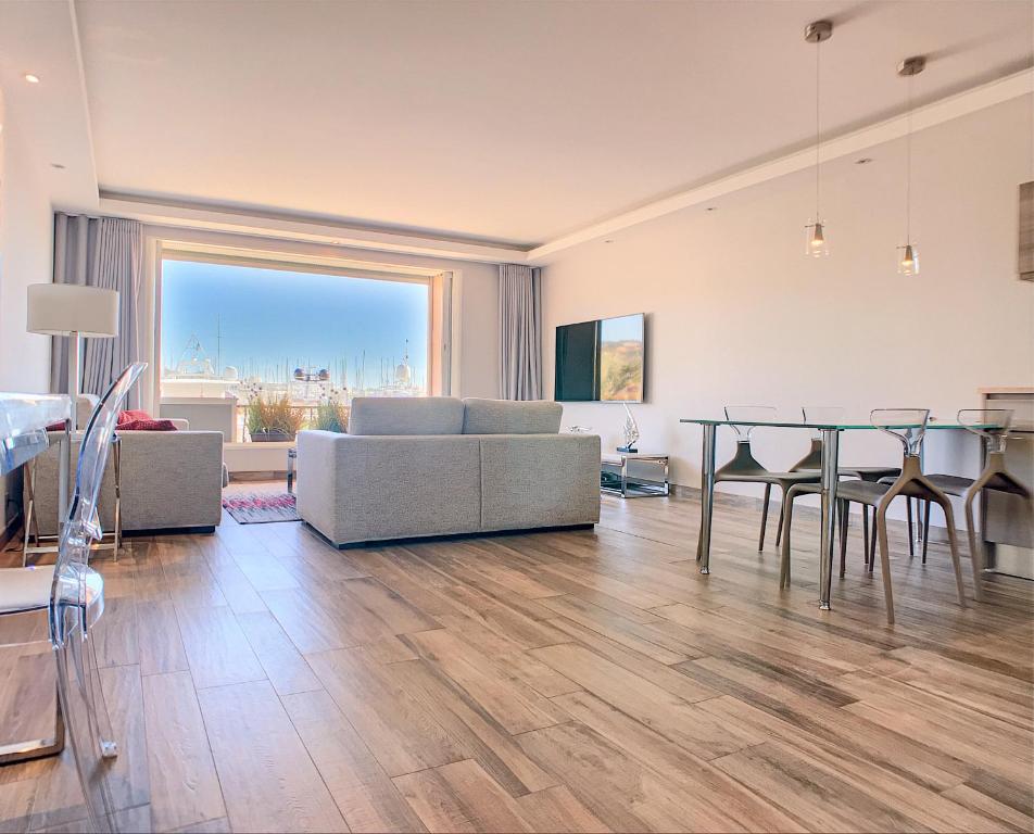 un salon avec une table, des chaises et un canapé dans l'établissement 16 Quai Saint-Pierre, à Cannes