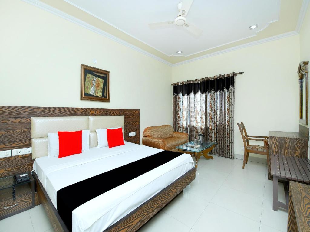 a bedroom with a large bed with red pillows at Hotel Sanjog International in Amritsar
