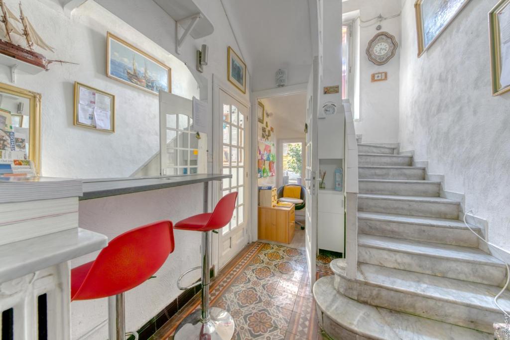 a hallway with stairs and red chairs in a house at Glamorgan in Antibes