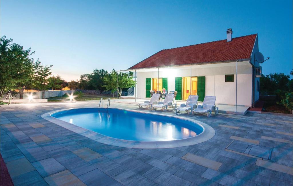 a swimming pool with chairs and a house at Nice Home In Lozovac With House A Panoramic View in Lozovac