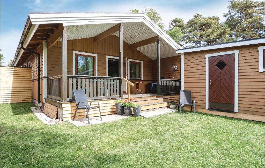 ein kleines Haus mit einer Terrasse und zwei Stühlen in der Unterkunft Awesome Home In Nybrostrand With Wifi in Kabusa
