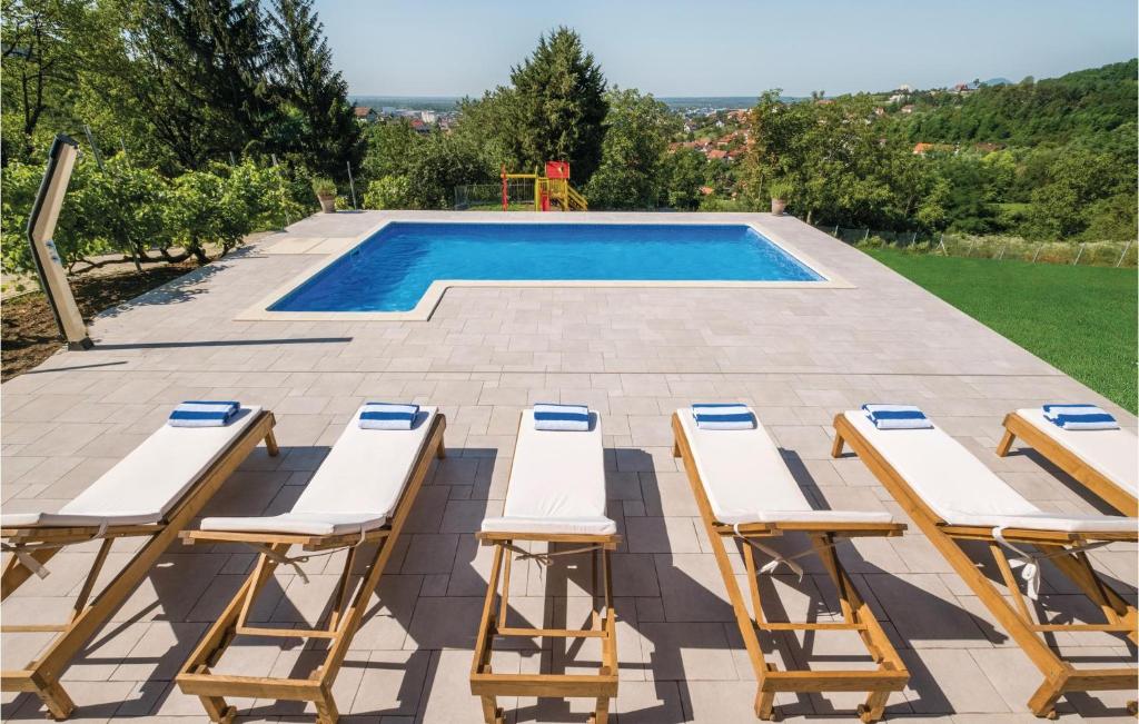 a patio with lounge chairs and a swimming pool at Beautiful Home In Zagreb With 2 Bedrooms, Wifi And Outdoor Swimming Pool in Zagreb