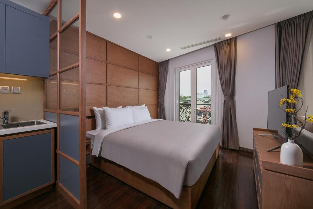 a hotel room with a bed and a kitchen at KEGON Hotel in Hanoi