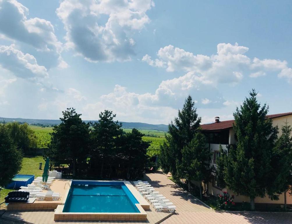 an image of a swimming pool with chairs and trees at Pensiunea Paradis Vrâncean in Focşani