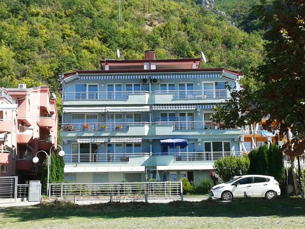 un edificio blu con una macchina parcheggiata di fronte di Matea Apartments a Ohrid