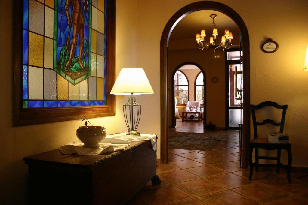 a hallway with a table with a lamp and stained glass windows at Hotel Golf Can Rafel in Corbera de Llobregat