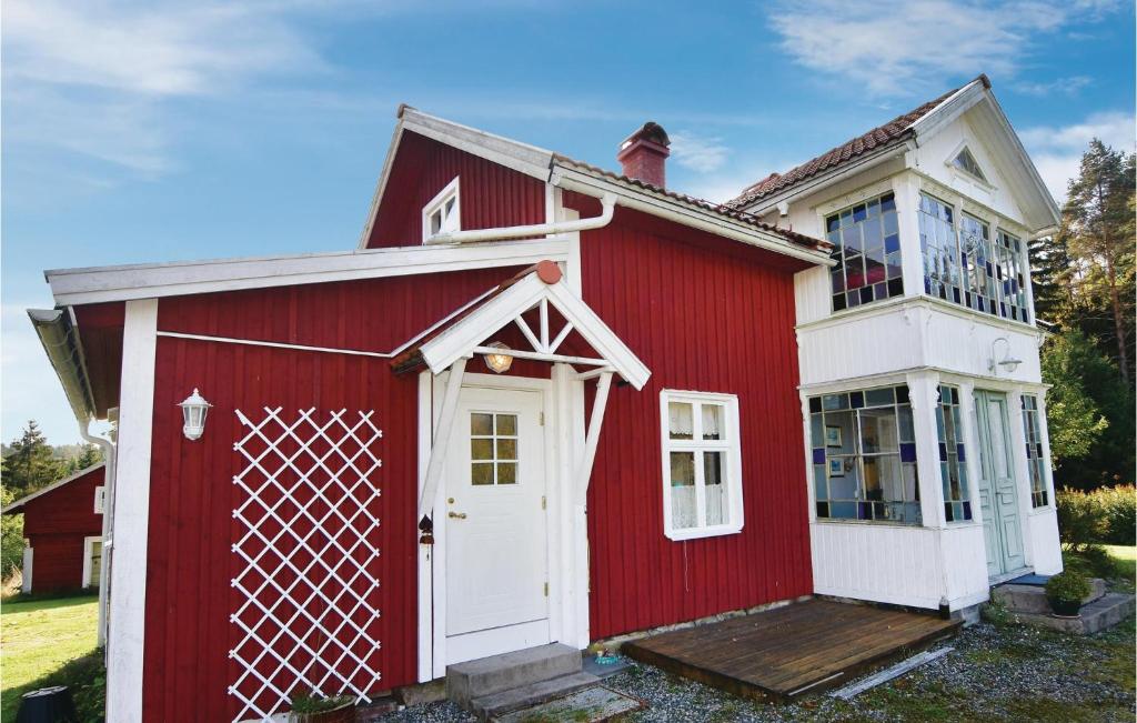 una casa roja y blanca con una puerta blanca en Cozy Home In rjng With Kitchen en Årjäng