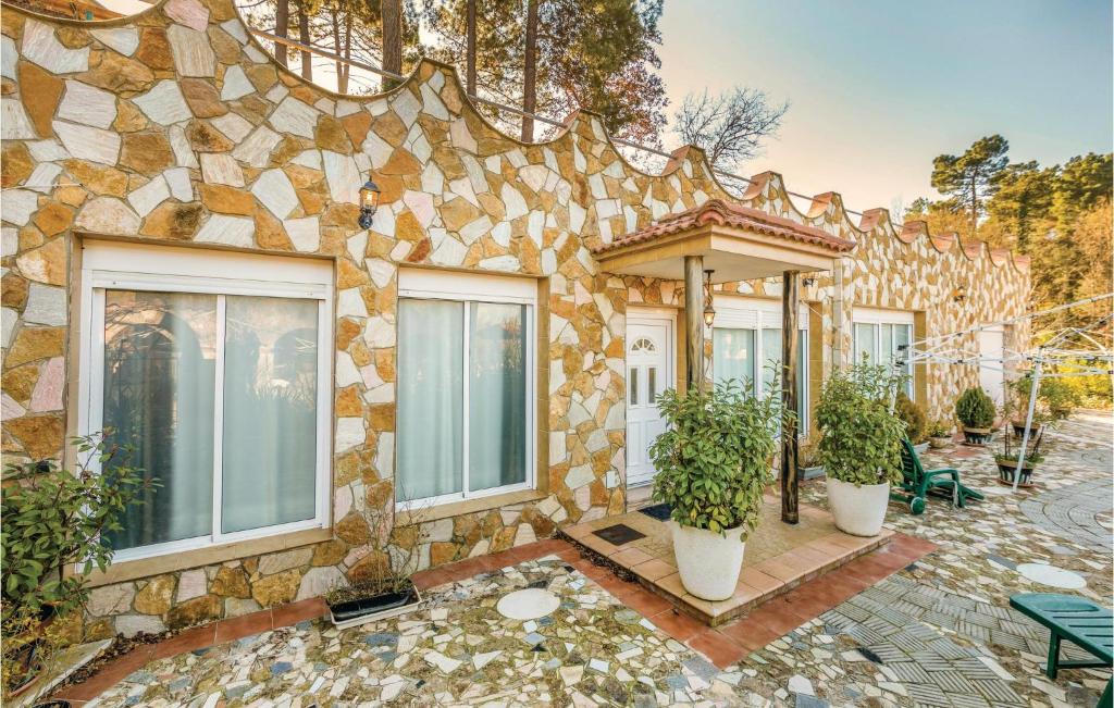 a house with a stone facade with potted plants at Cozy Home In Puig Ventos With Outdoor Swimming Pool in Mont Barbat