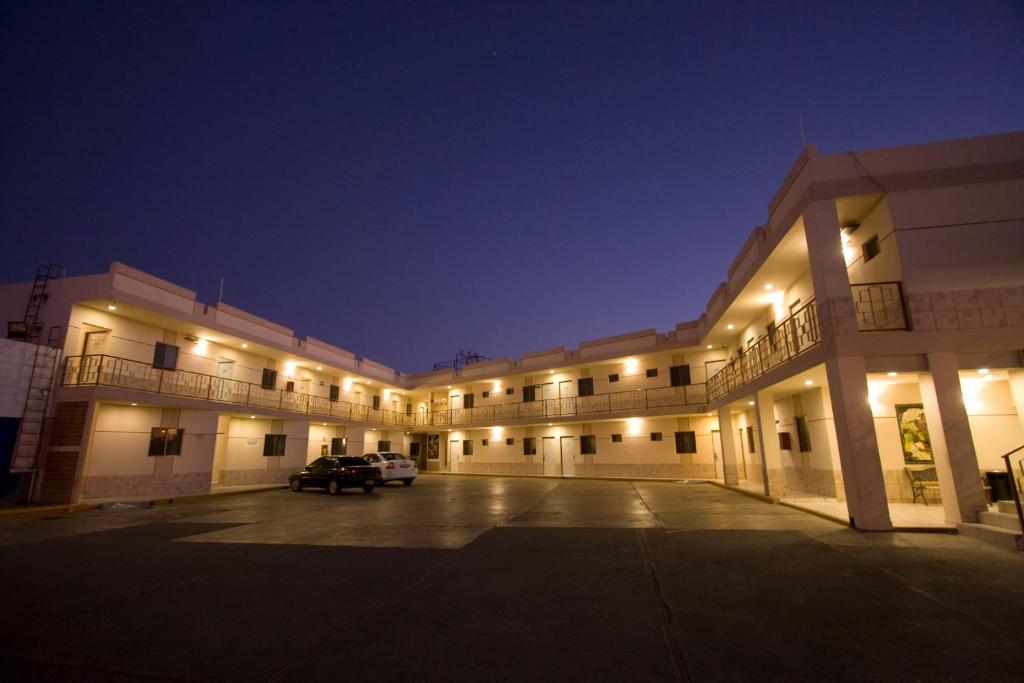 un grand bâtiment avec un parking la nuit dans l'établissement Hotel Hacienda Nainari, à Ciudad Obregón