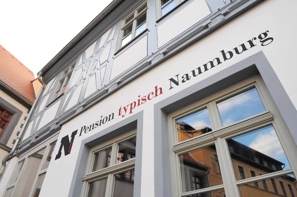 een gebouw met een bord aan de zijkant bij Pension Typisch Naumburg in Naumburg