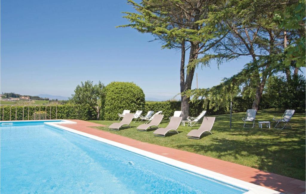 a group of lounge chairs and a swimming pool at Gallonero 2 in Tavarnelle Val di Pesa
