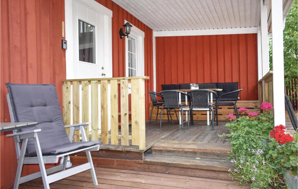 a deck with chairs and a table on a house at Awesome Home In Lttorp With Kitchen in Löttorp