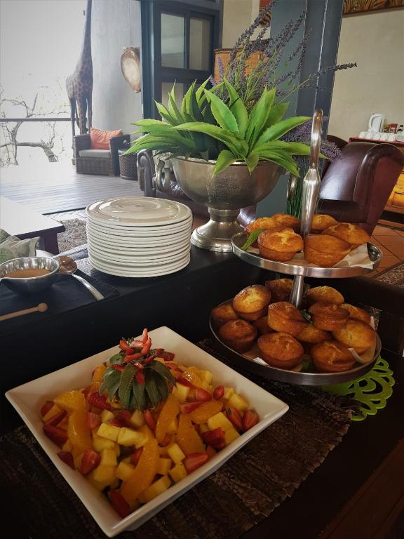 a table topped with plates of food and a plate of fruit at Greenfire Game Lodge in Balule Game Reserve