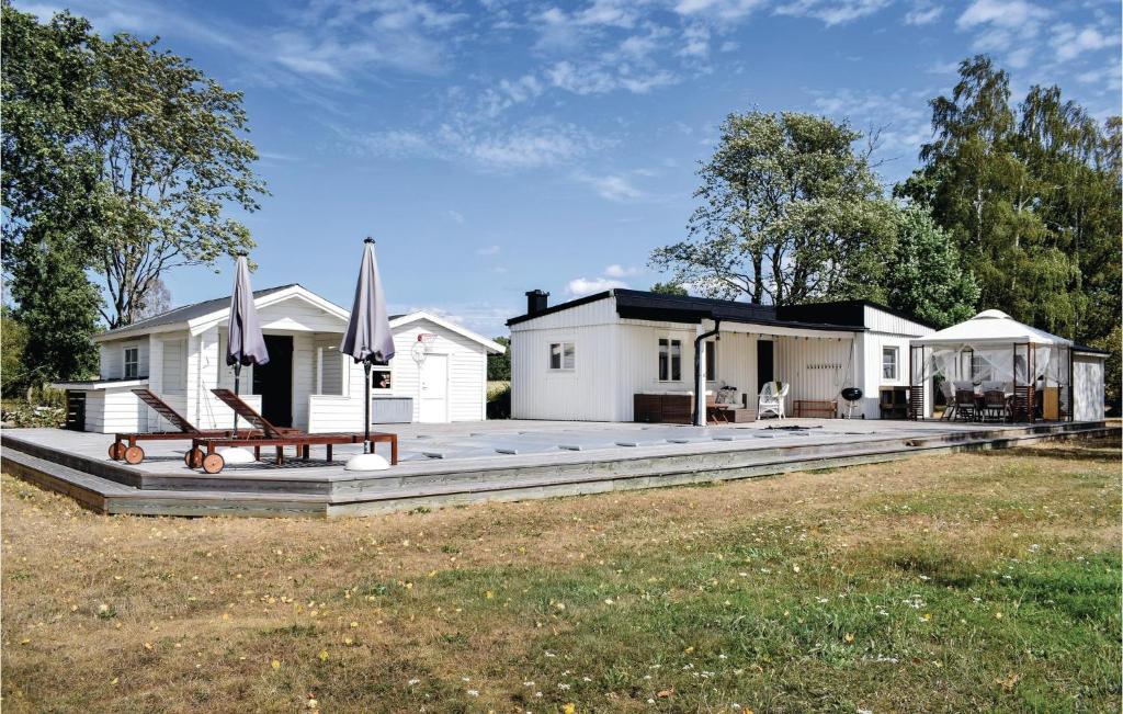 una casa con un gran patio con una mesa y sombrillas en 3 Bedroom Gorgeous Home In Lttorp, en Löttorp