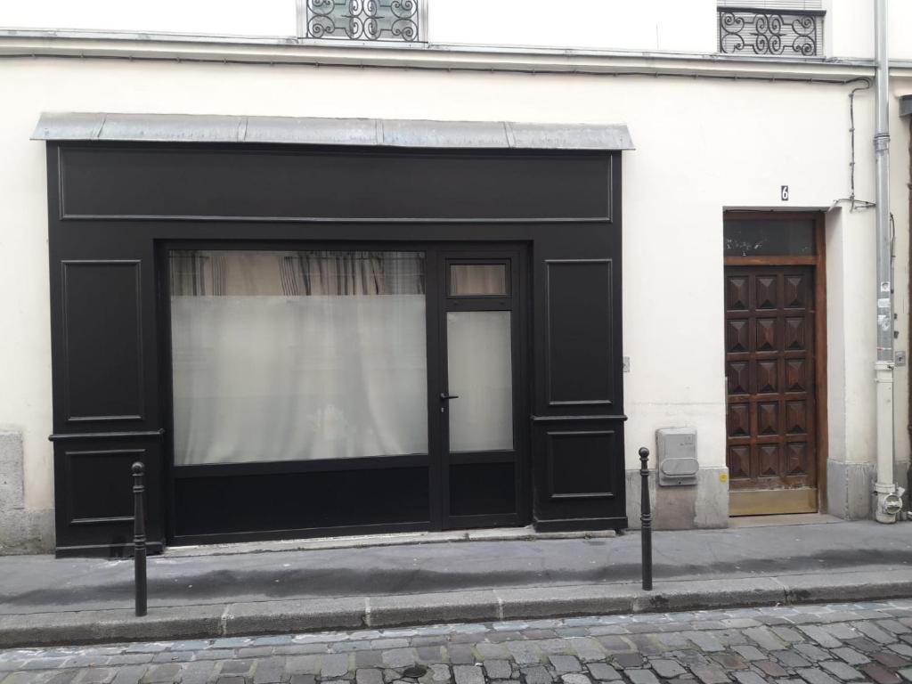 a building with a black door and a window at IMHOST - Amazing architect studio Père Lachaise in Paris
