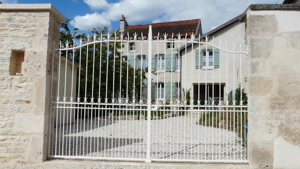 a white gate in front of a house at La Promenade en Champagne in Mussy-sur-Seine
