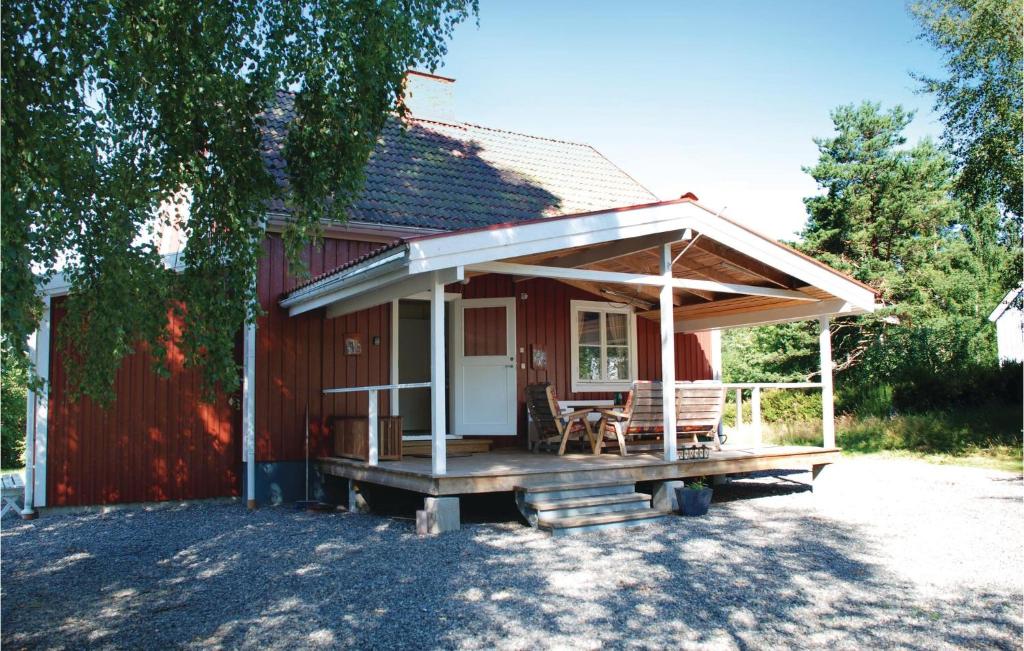 a small red house with a covered porch at Stunning Home In Nordmarkshyttan in Nordmarkshyttan
