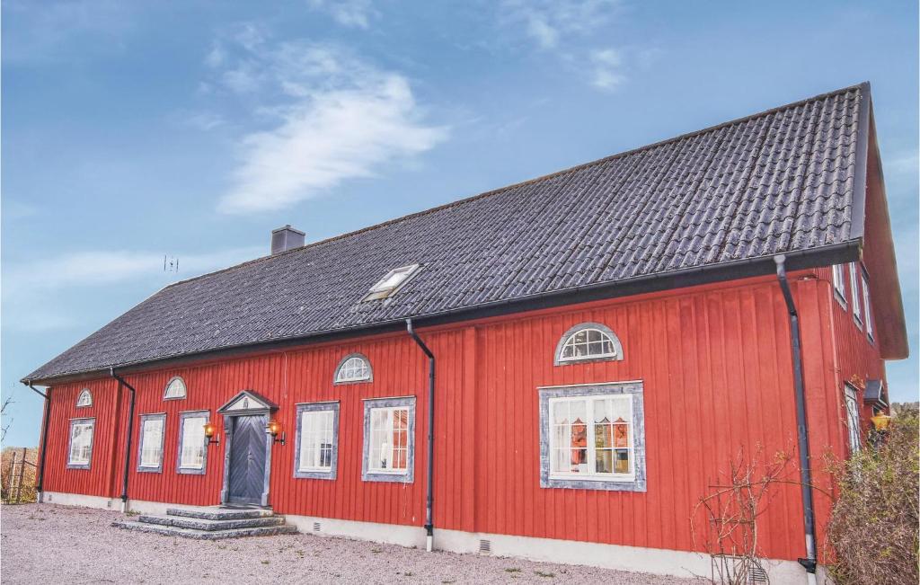 a red barn with a black roof at Awesome Home In Tidaholm With Kitchen in Älvstorp