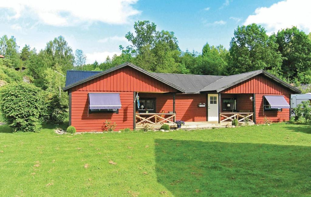 Cabaña roja con porche y césped en Nice Home In Grnna With Wifi, en Gränna