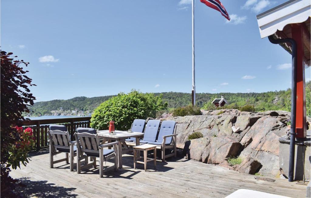 a table and chairs on a deck with a view of the water at 1 Bedroom Awesome Home In Tvedestrand in Tvedestrand