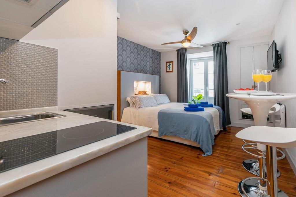 a kitchen and a bedroom with a bed in a room at Cozy and perfect location Bairro Alto Chiado in Lisbon
